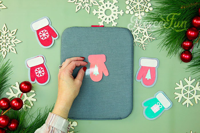 Heat pressing HTV onto a felt mitten ornament using fleecefun's free guide.
