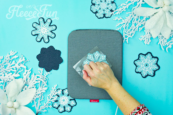 Applying heat transfer vinyl to snowflake ornament from fleecefun guide