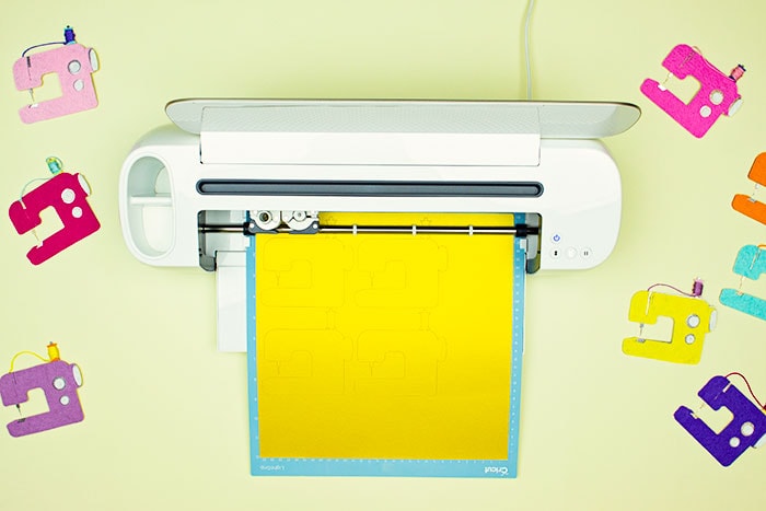 cutting the cardstock using cricut. This DIY Sewing Room Décor is a happy addition to your creative space! This cute sewing machine pattern and cut file is perfect for décor, ornaments, garland and more! With a few simple materials you can make this decoration for your sewing studio or a friend! I'm providing you with a PDF plus a JPEG if you want to cut it out using a Cricut.