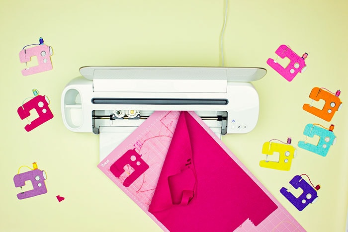 cutting the felt using cricut. This DIY Sewing Room Décor is a happy addition to your creative space! This cute sewing machine pattern and cut file is perfect for décor, ornaments, garland and more! With a few simple materials you can make this decoration for your sewing studio or a friend! I'm providing you with a PDF plus a JPEG if you want to cut it out using a Cricut.