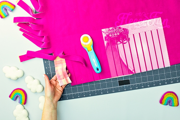 Learn how to use Fleece Fun's Tie Blanket Ruler with this handy tutorial. While tying no sew fleece blankets is easy - CUTTING the thing is and entirely different matter. It takes forever to measure, mark and cut the blanket to get to the tying part of the project! But thanks to this handy Tie Blanket Ruler or Tie Blanket Template (that also happens to be patent pending) you can cut down the cutting and marking to a fraction of the time.