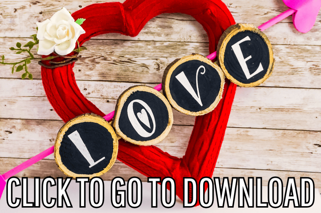 A vibrant red heart-shaped wreath adorned with flowers and small blackboard circles spelling out "LOVE" in white chalk, displayed on a rustic wooden background. Text at the bottom reads "CLICK TO GO TO DOWNLOAD."