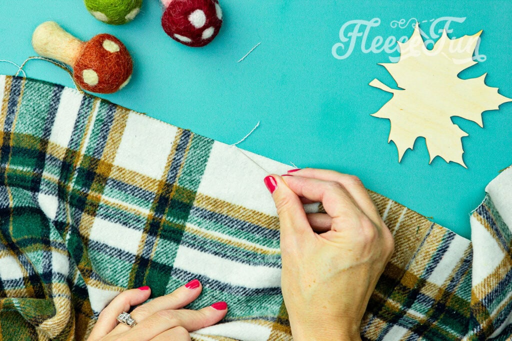 pick off the top thread of the end that we just cut. Gently pull on the string, unraveling it from the blanket.
