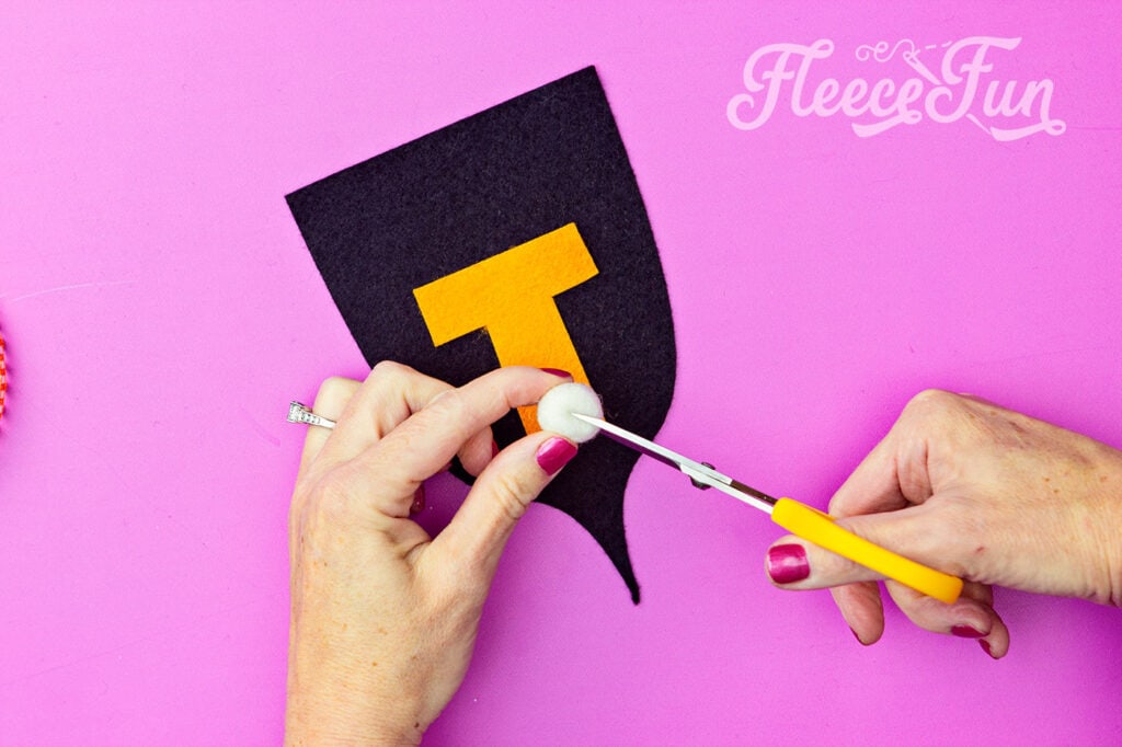 Adding pom poms to the Trick or Treat banner with fleecefun’s free template and tutorial.