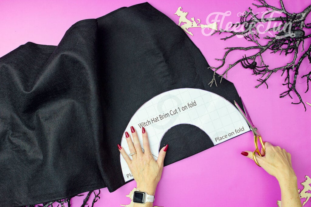 Cutting out the pieces for the DIY Hedge Witch Hat using fleece fun’s free pattern.