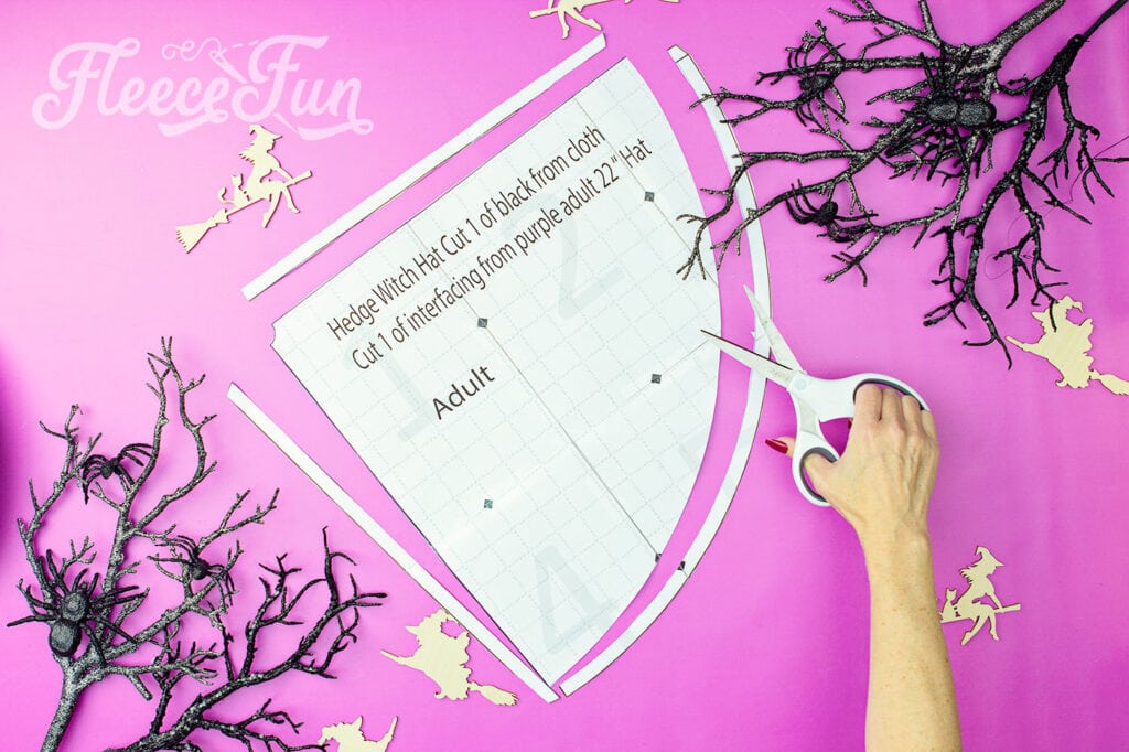 Cutting down the free witch hat pattern pieces for the DIY Hedge Witch Hat using fleece fun’s free pattern.