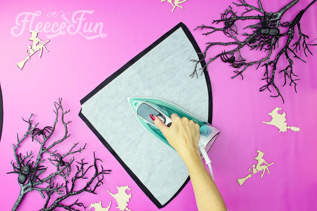 Ironing on the fusible interfacing to the free witch hat pattern.