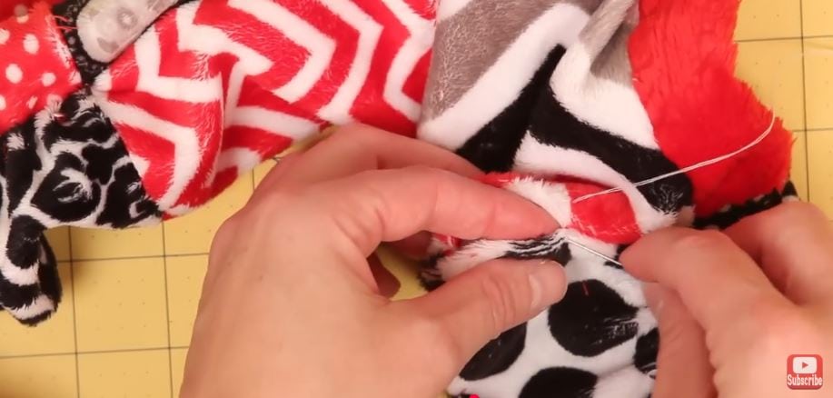 Hand-stitching the gap shut to finish the charmed scarf.