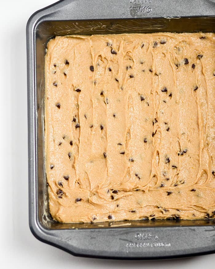 Pouring into the lined pan and baking till done.